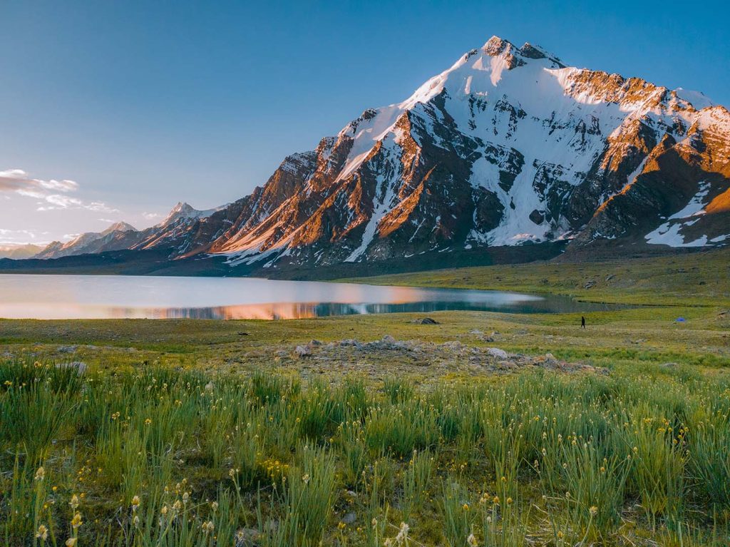 Morning at the Karambar Lake, sunshine on the mountain in the background.