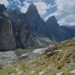 Nangma Valley Trek 3 Green meadows of Nangma Valley in the foreground and sky towering rocky granite mountains in the background under a sunny day.