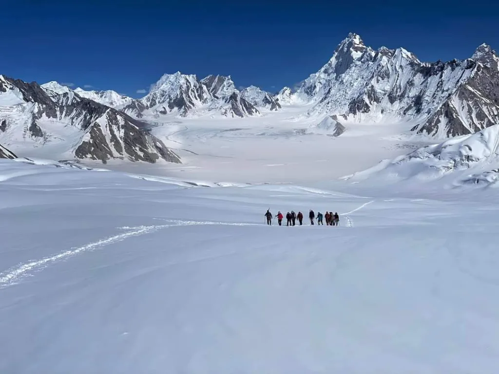 Trekkers crossing the grand glacial basin Snow Lake. Treks in Pakistan