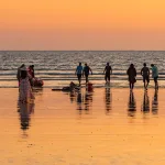 people at beach enjoying sunset