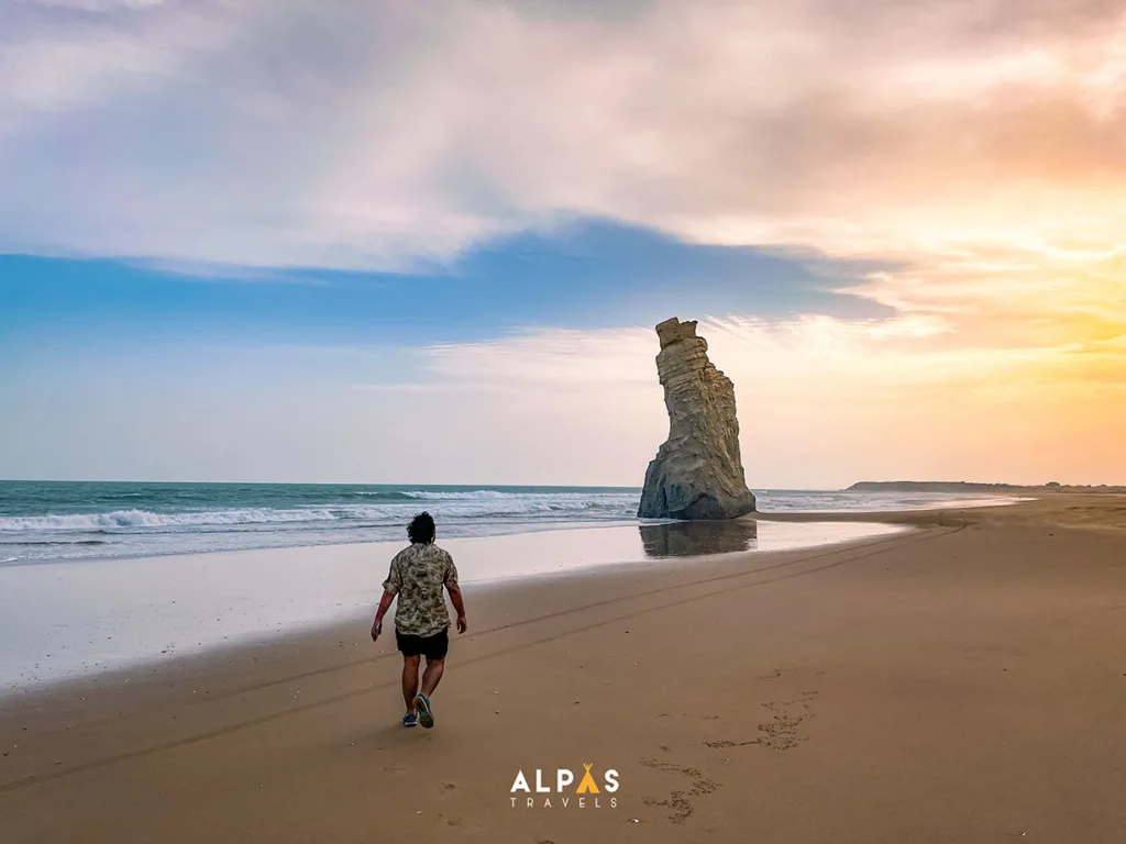 A person walking on the shore during sunset at the Sapat Beach in Balochistan