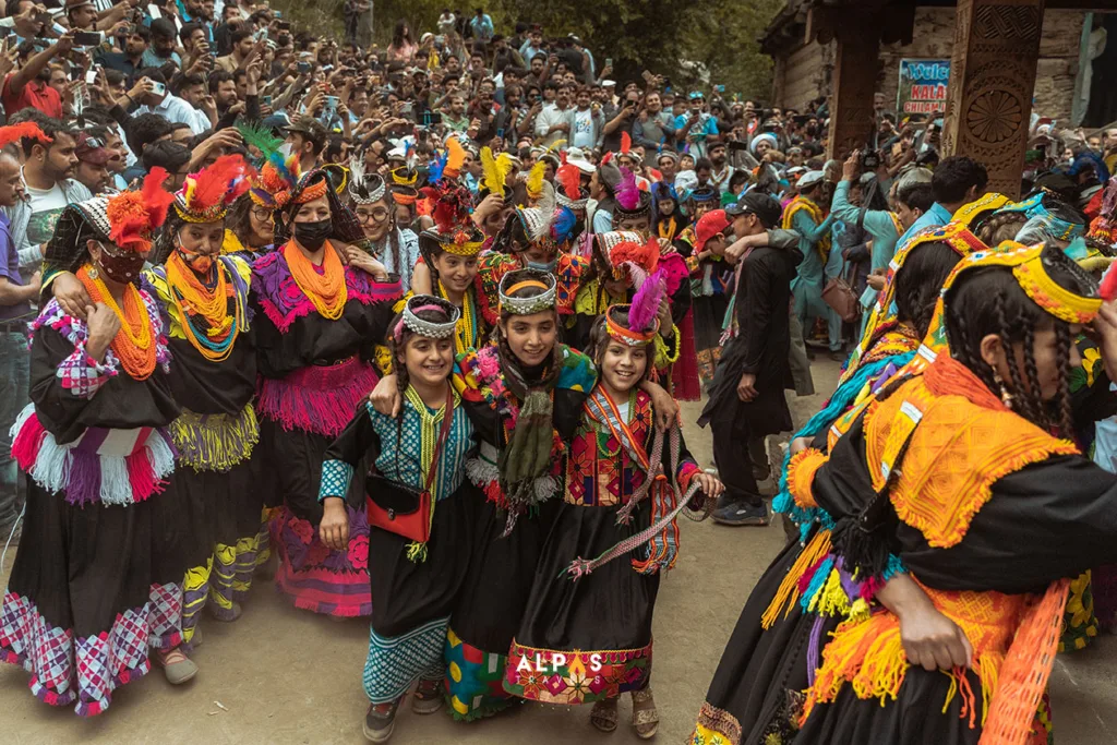 Crowds of Kalasha people dancing at the dancing hall in Bumburet at Chilam Joshi